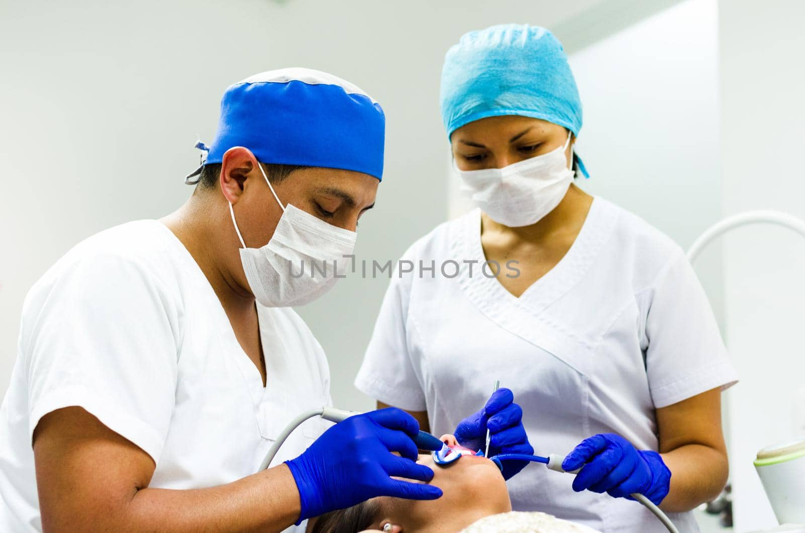 Dentist and his assistant carrying out a thorough examination. by Peruphotoart