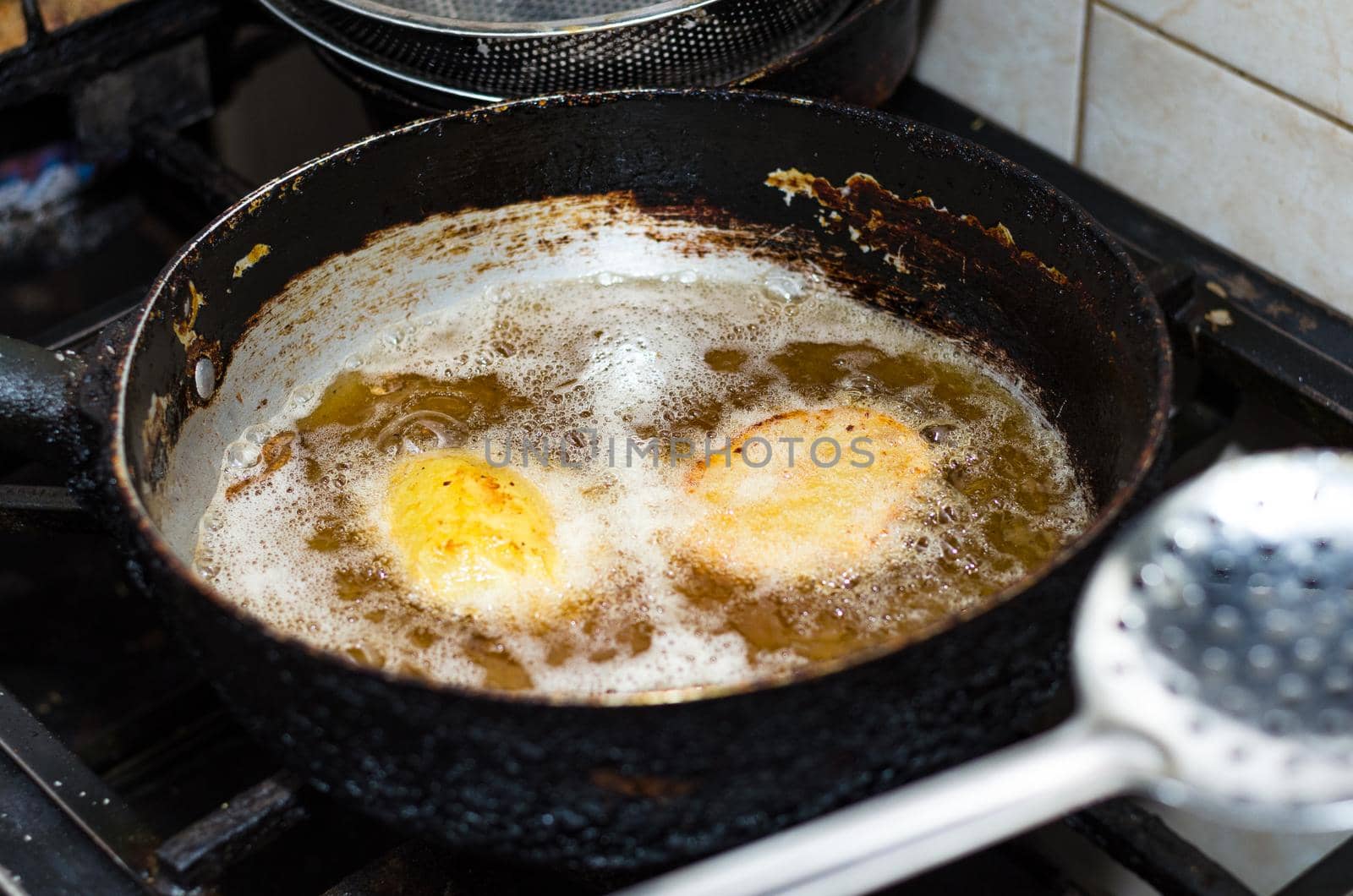 Fried potatoes in a frying pan on stove. Homemade cuisine. Potatoes is frying on stove.