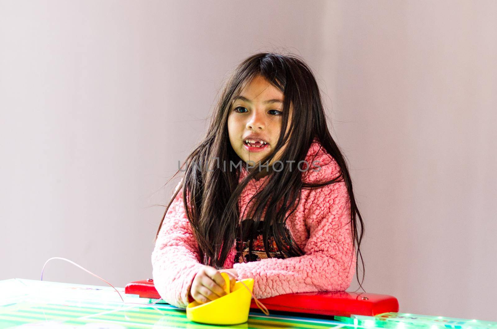 Concentrated and enthusiastic girl plays table hockey