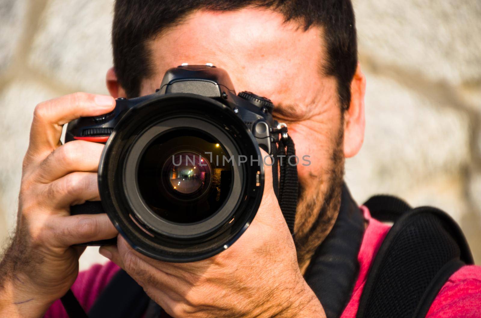 Photographer, taking photos with his professional camera with both hands