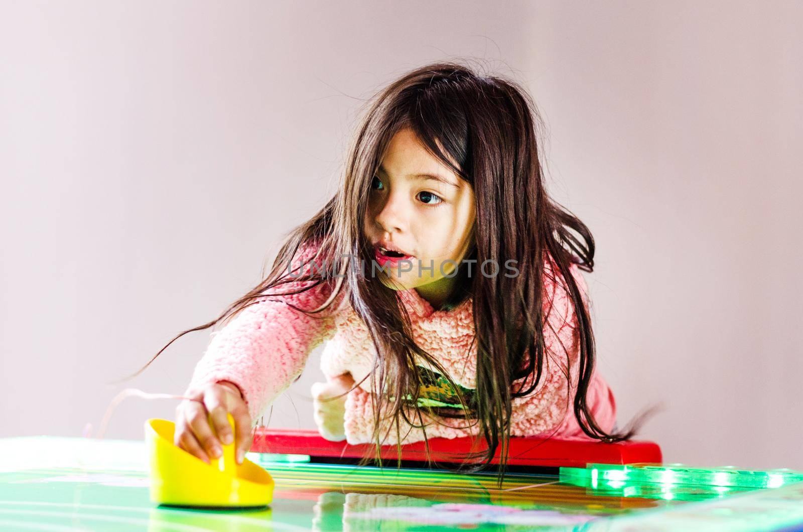 Concentrated and enthusiastic girl plays table hockey