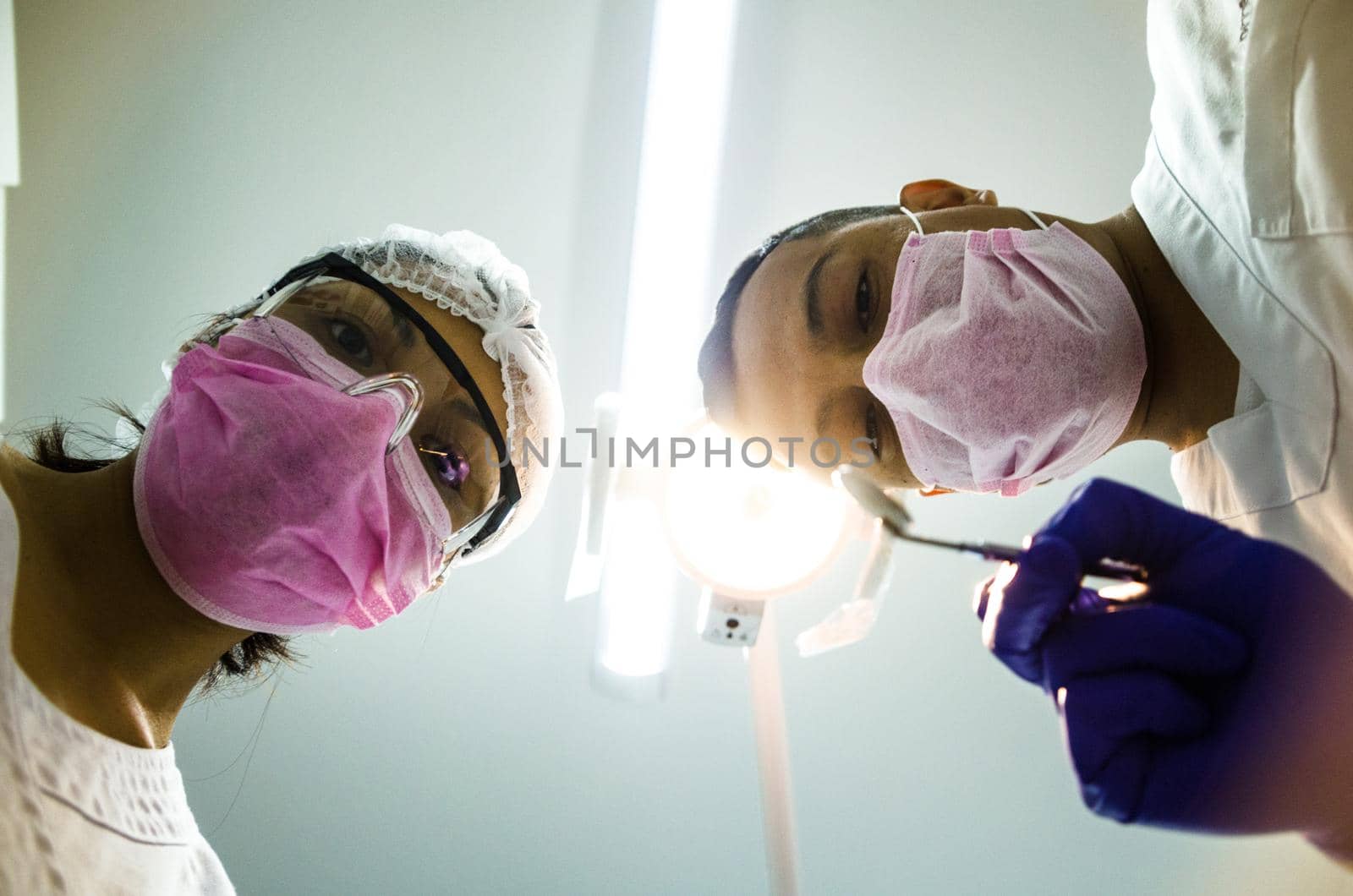 Portrait of two surgeons at work, operating in uniform, looking at the camera. by Peruphotoart