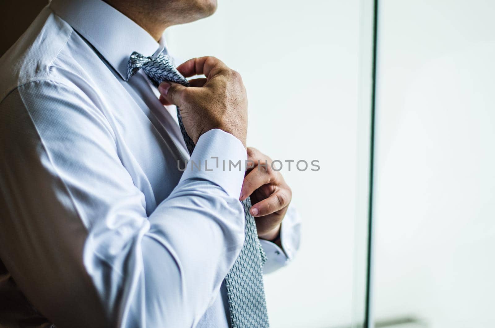 Businessman making a tie knot, formal suit