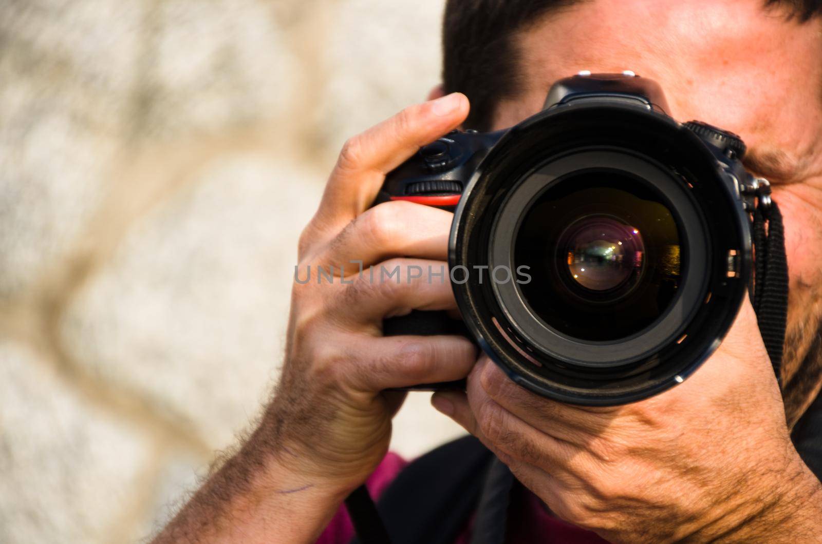 Photographer, taking photos with his professional camera with both hands