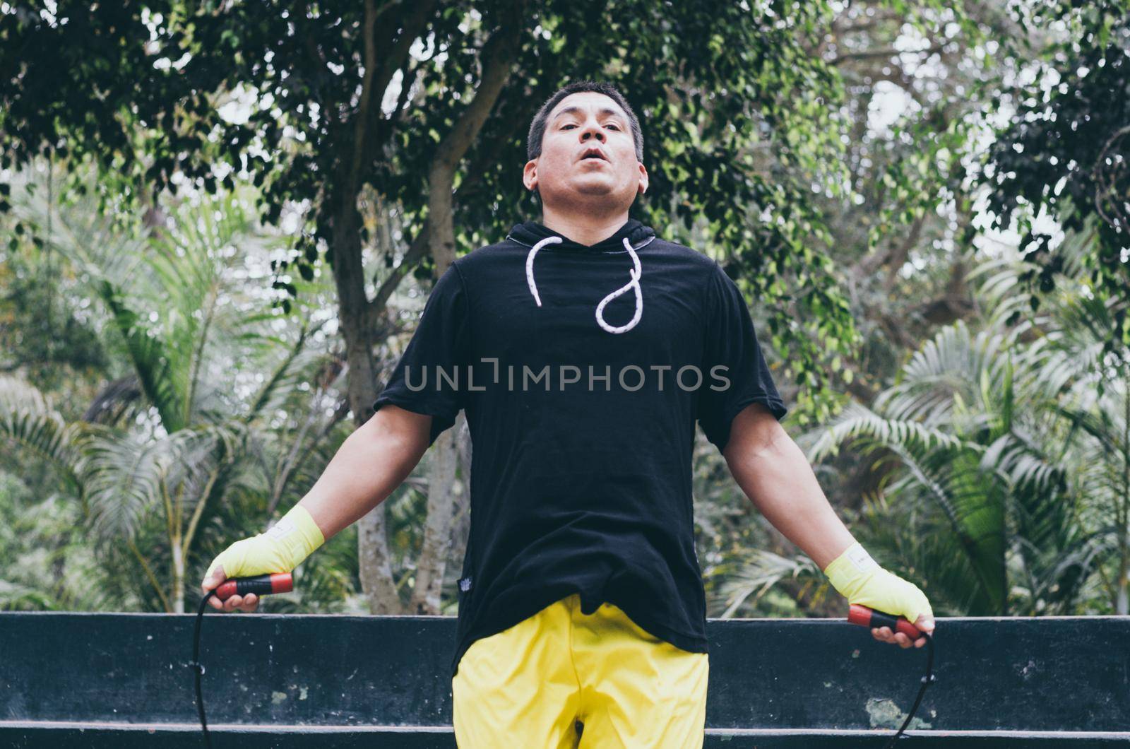 Portrait of a physically fit man posing with skipping rope