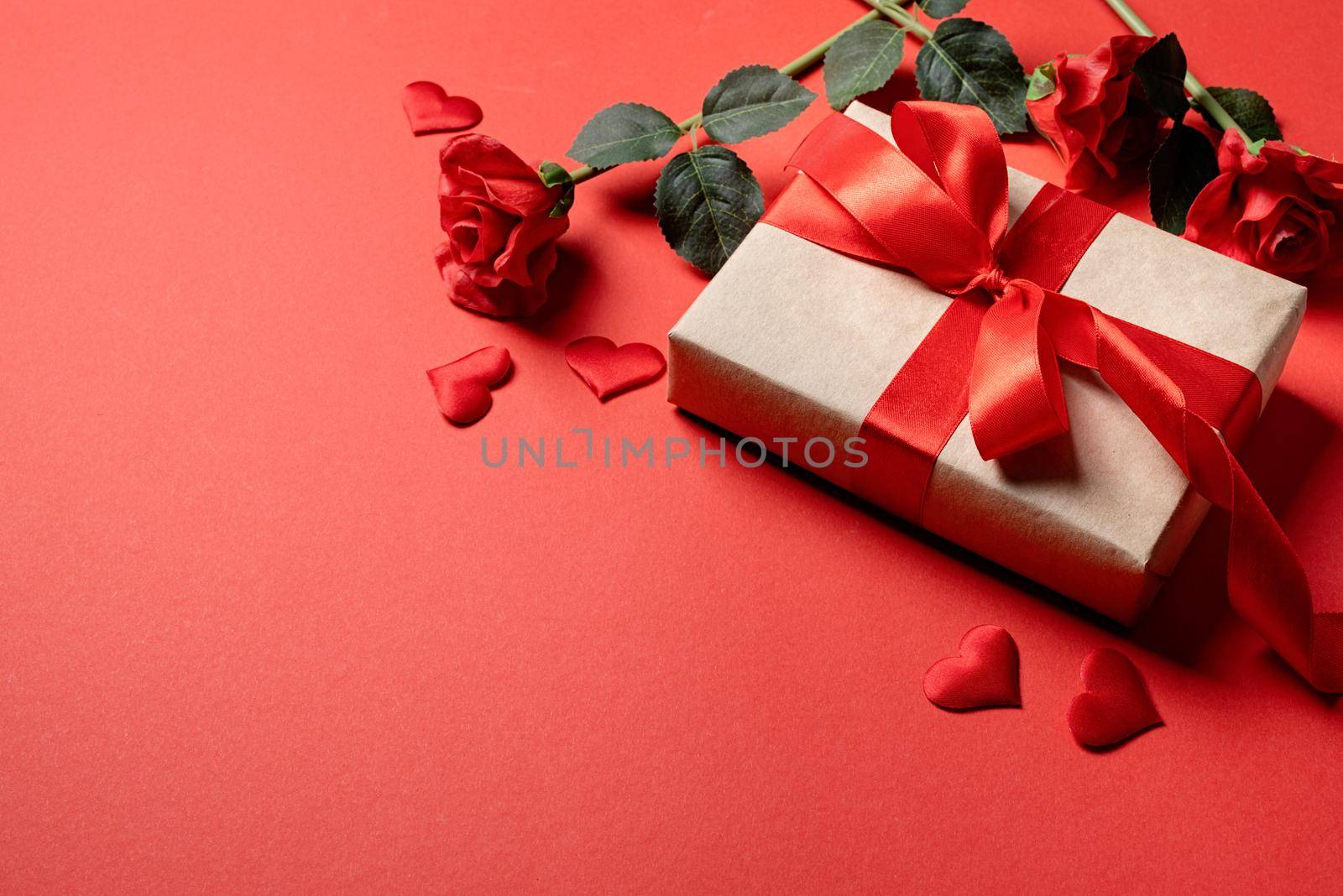 Red solid background with red hearts, gifts and confetti. The concept of Valentine Day.