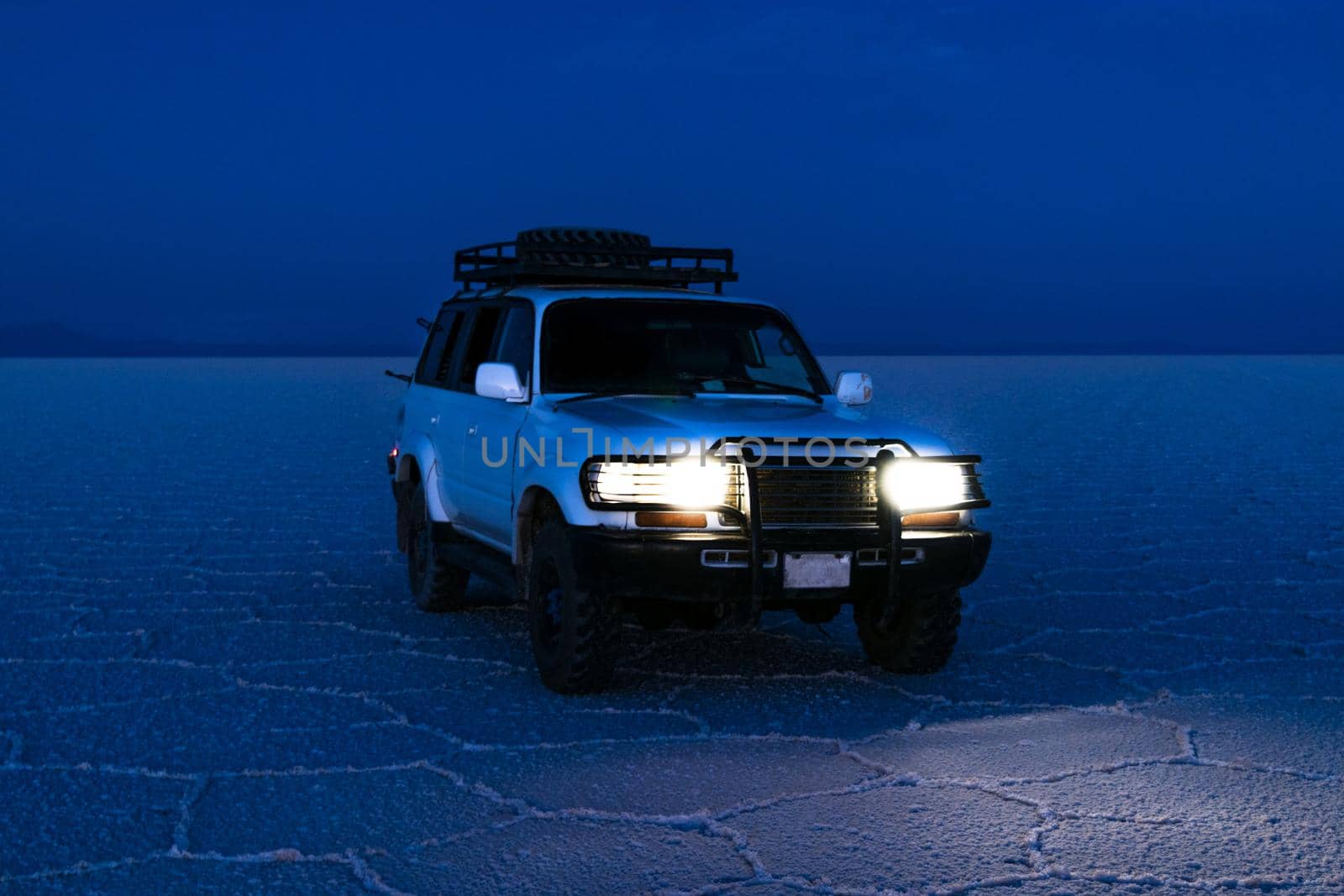 The car in the Uyuni salt flat, is located at an altitude of 4000 meters above sea level on the plateau of the Bolivian Altiplano