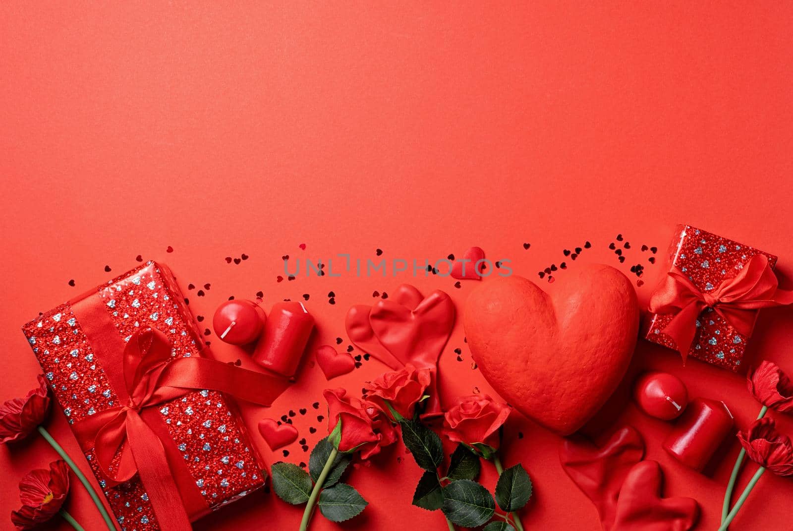 Red solid background with red hearts, gifts and candles. The concept of Valentine Day.