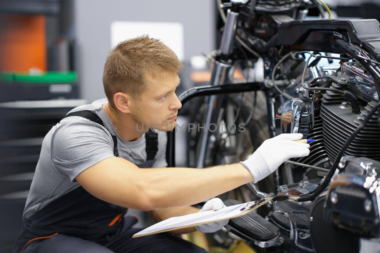 A man in the garage is checking a motorcycle by kuprevich