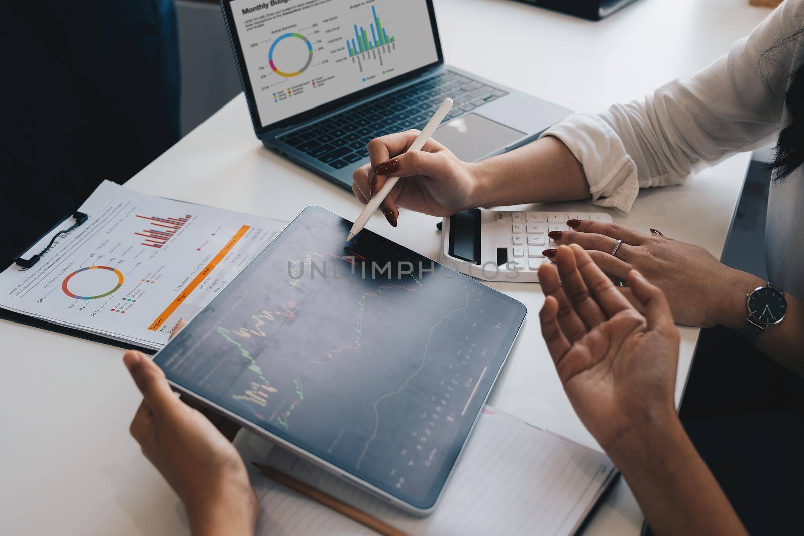 Two business woman working and discussing business together in a meeting, finance chart report from digital tablet, financial accounting concept