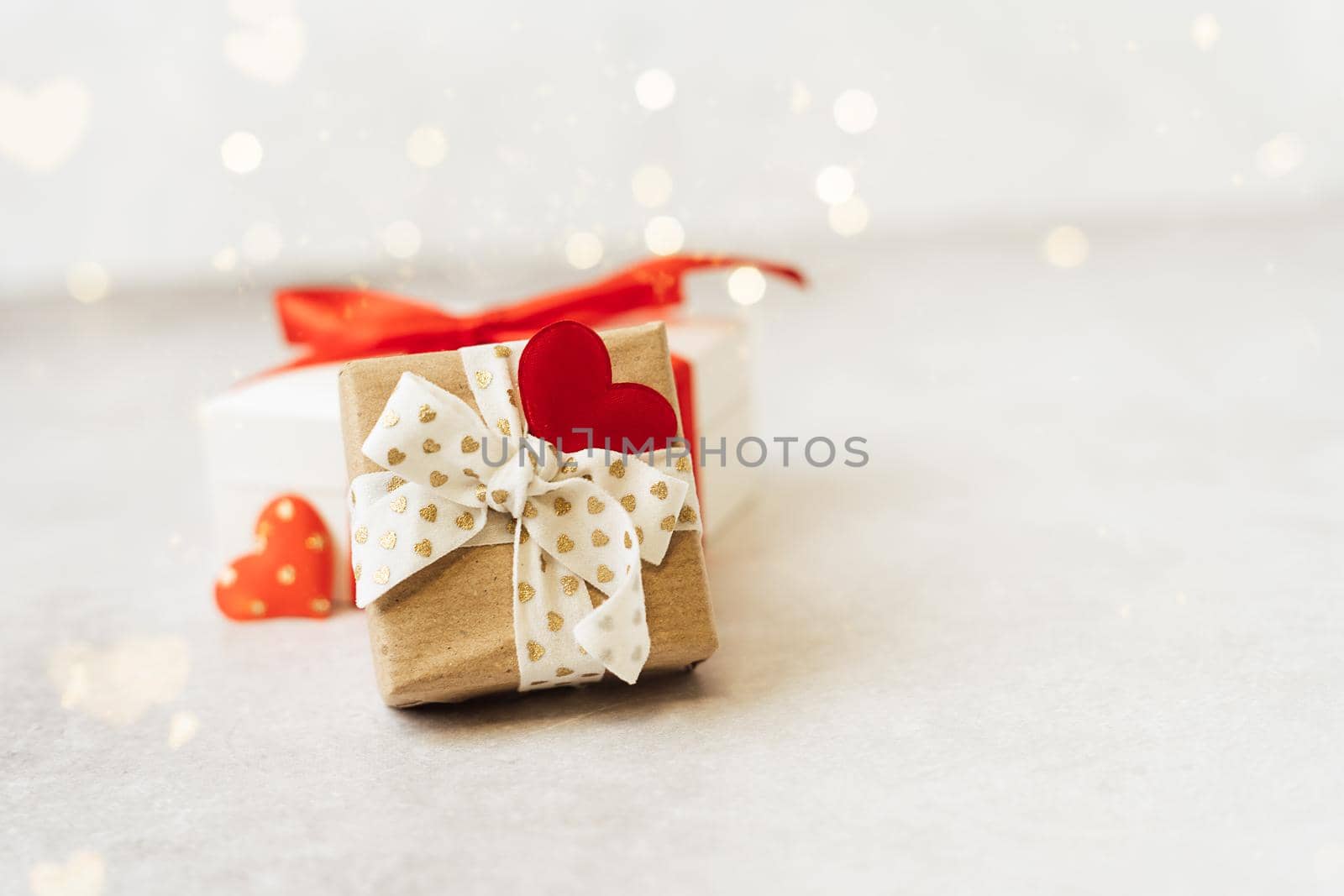 Gift or present box with red bow and heart shape on lights background. Copy space for text and design. Valentine day gift. Banner for Christmas, hew year, birthday concept.