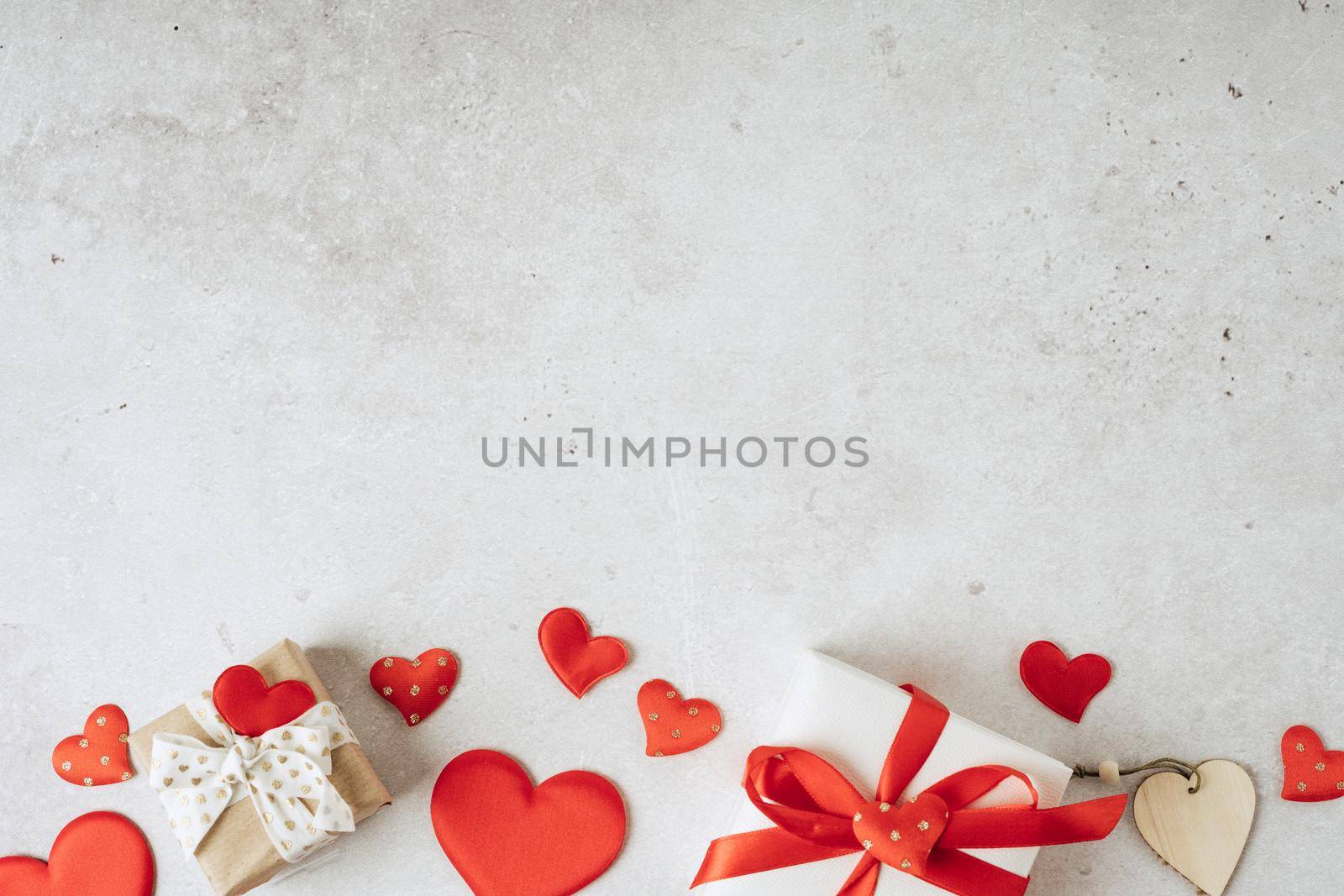 Background with gift and hearts with free space for text on concrete grey background. Valentines day concept. Mother's Day concept. Greetings card. Copy space. Flat lay, top view.