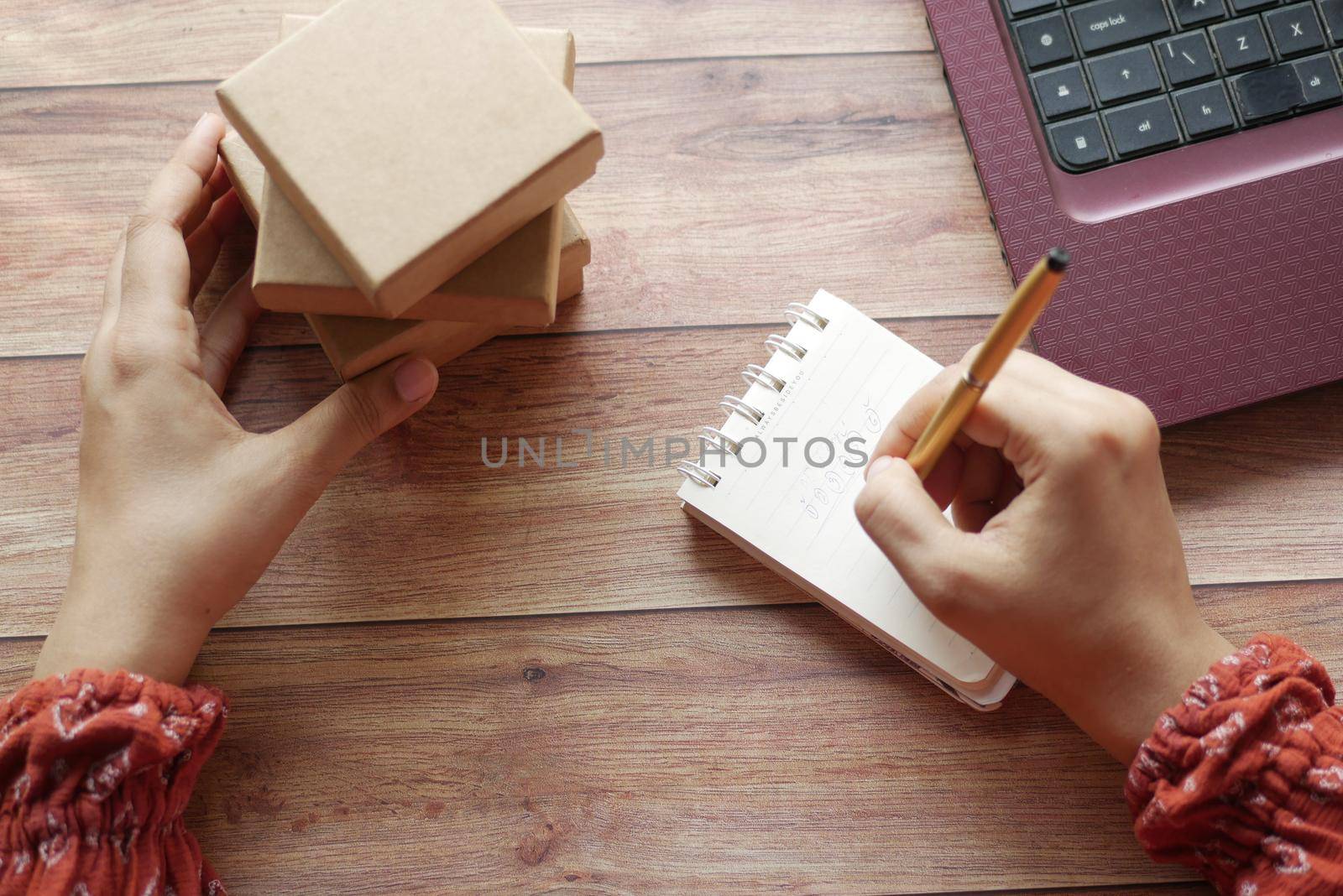 stack of cardboard parcels and laptop on table .