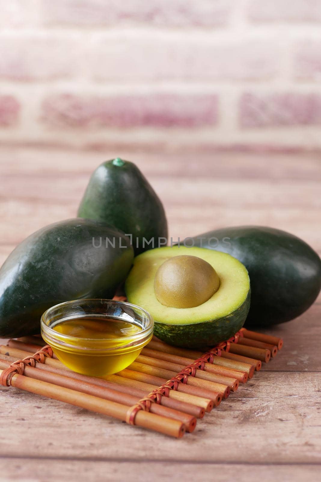 oil and slice of avocado on wooden table .