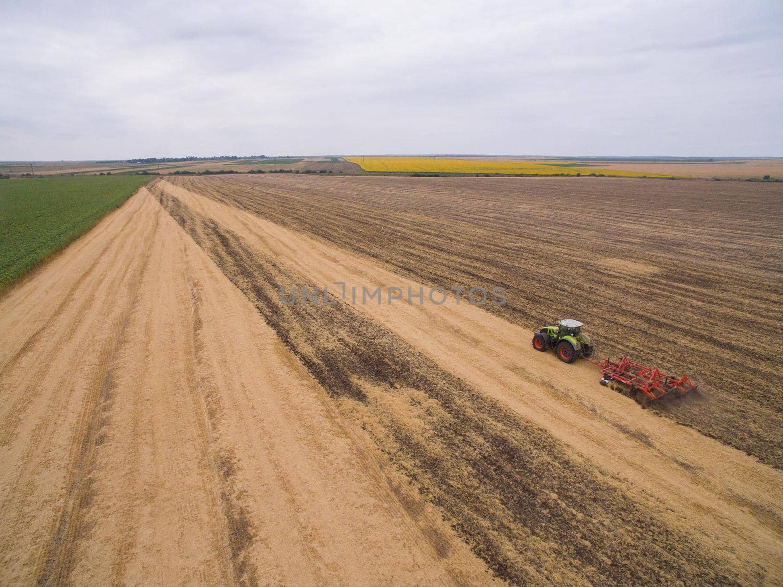Harvesting in the field. Aerial view. Land cultivation with a tractor by TrEKone