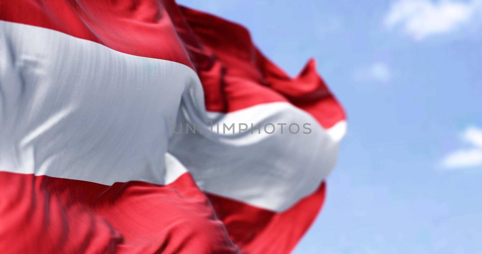 Detail of the national flag of Austria waving in the wind on a clear day. Democracy and politics. European country. Selective focus.