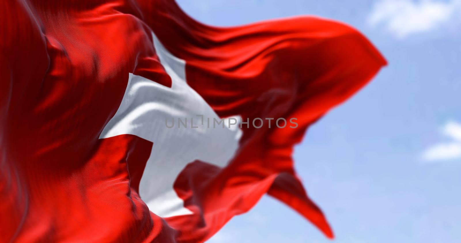 Detail of the national flag of Switzerland waving in the wind on a clear day by rarrarorro