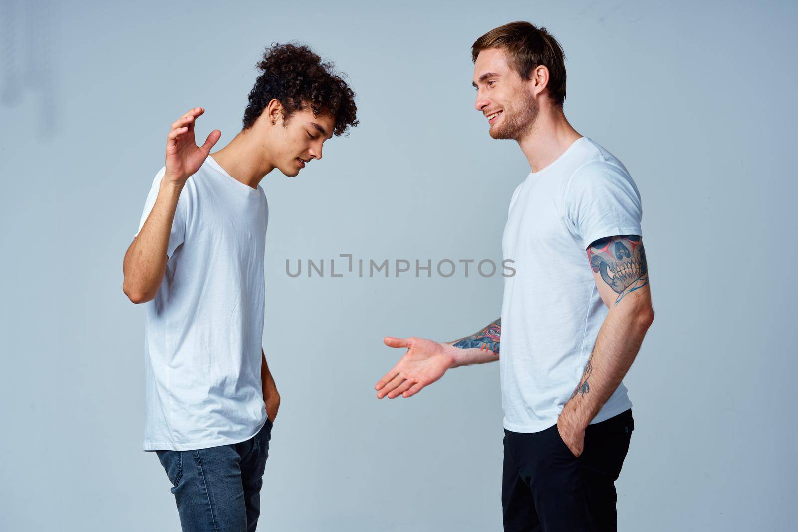 two men in t-shirts friendship communication light background by SHOTPRIME