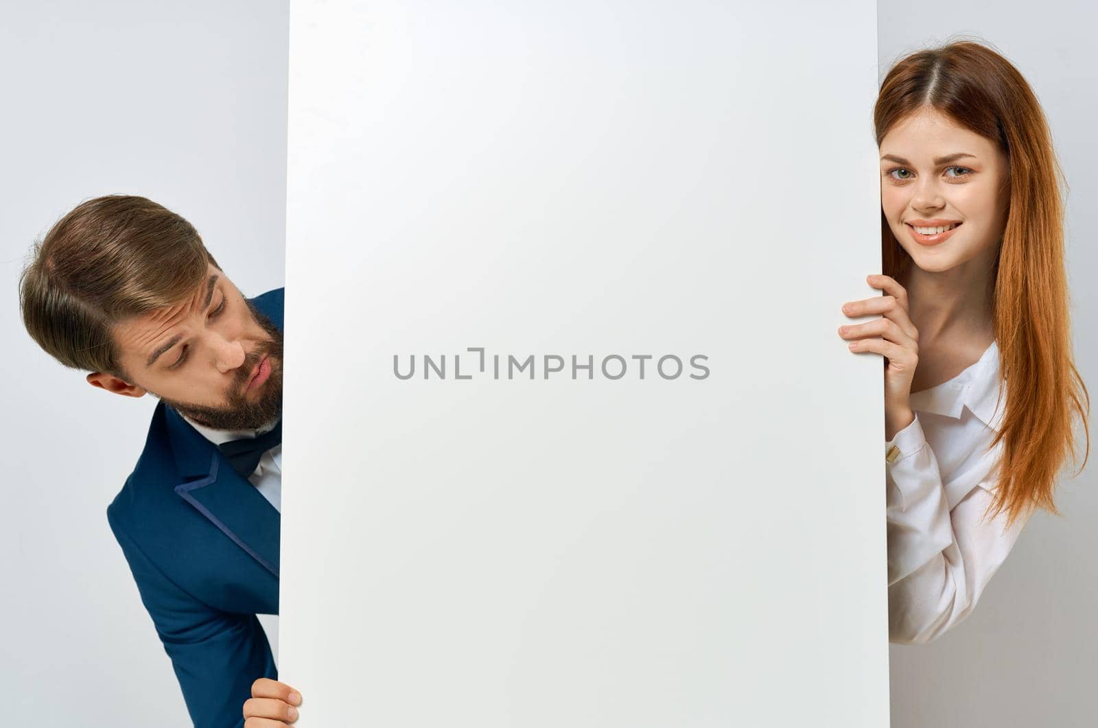 funny man and woman with white mockup poster advertising sign White background. High quality photo