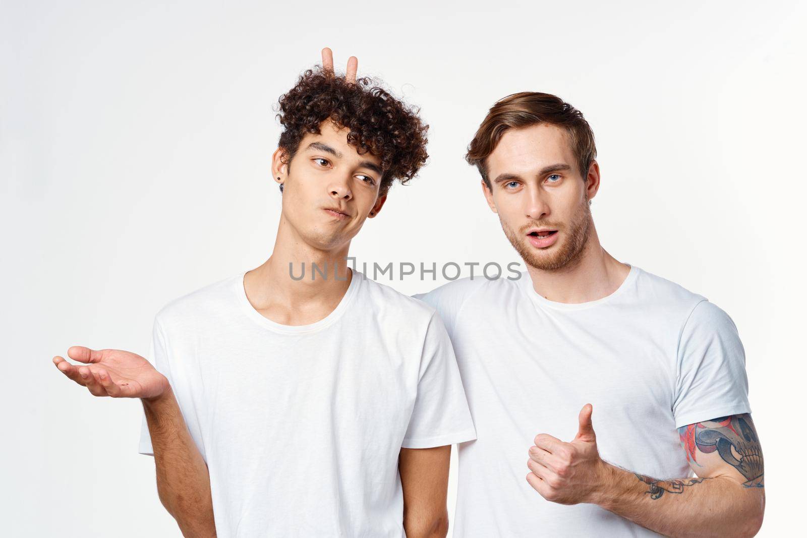 two men in t-shirts friendship communication light background. High quality photo