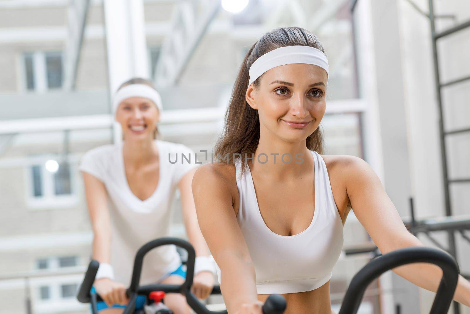 Small group of young people exercising on bikes in fitness center