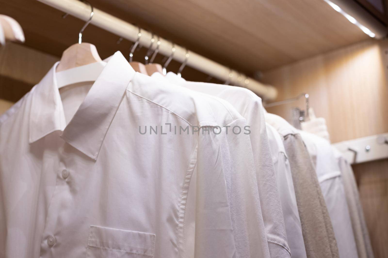 Clothes on a rail in a wardrobe. Seasonal capsule for easy dressing, order in things, cleaning out