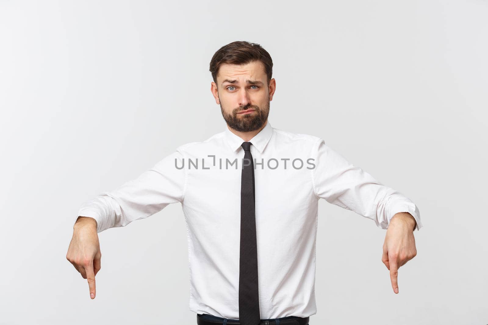 Bearded serious businessman pointing finger at you. Isolated on grey studio background.
