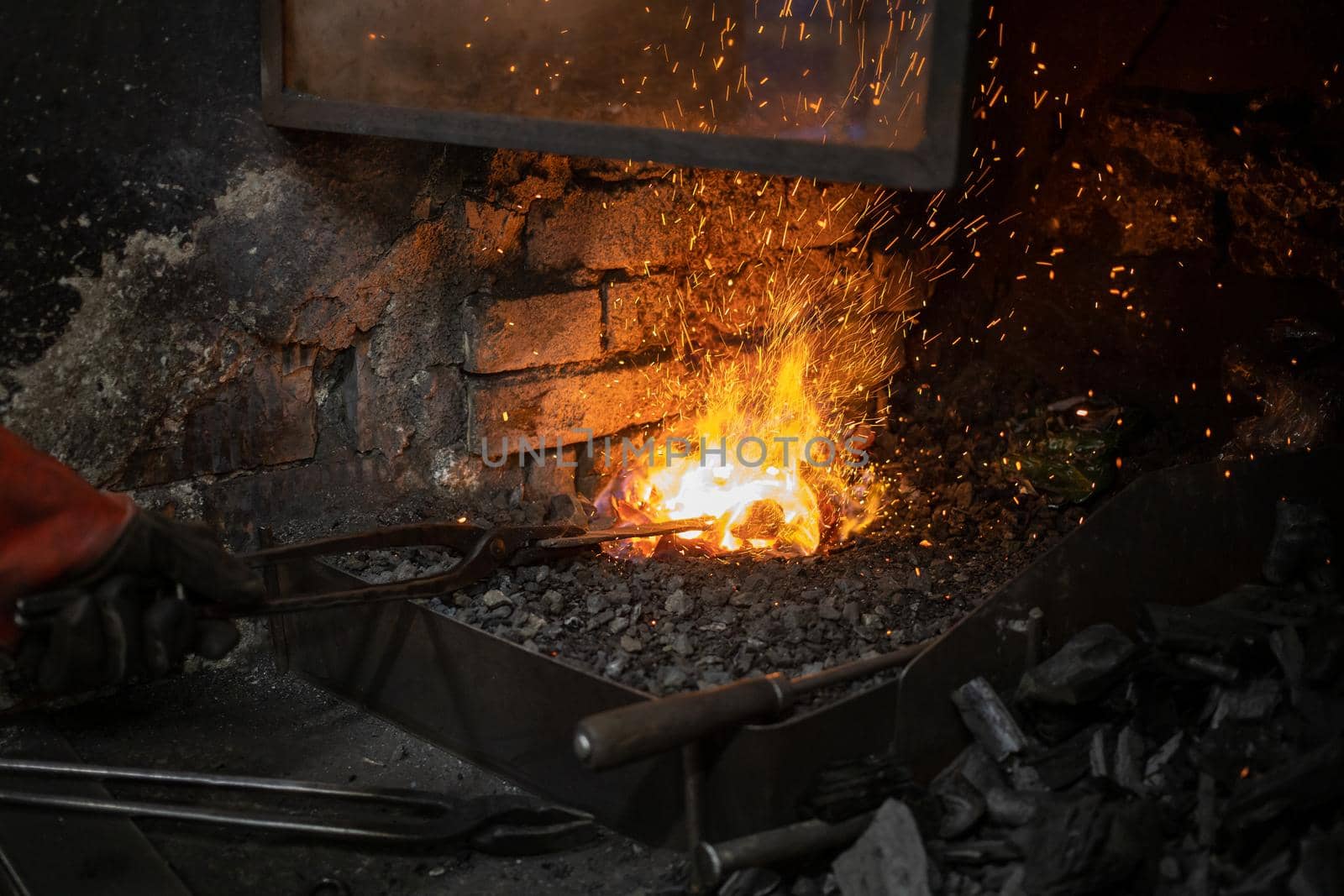 blacksmith warming blank metal on coal fire by Chechotkin