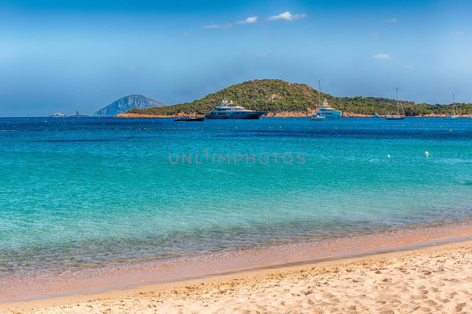 Luxury yachts standing in front of Liscia Ruja, one of the most beautiful beaches in Costa Smeralda, Sardinia, Italy