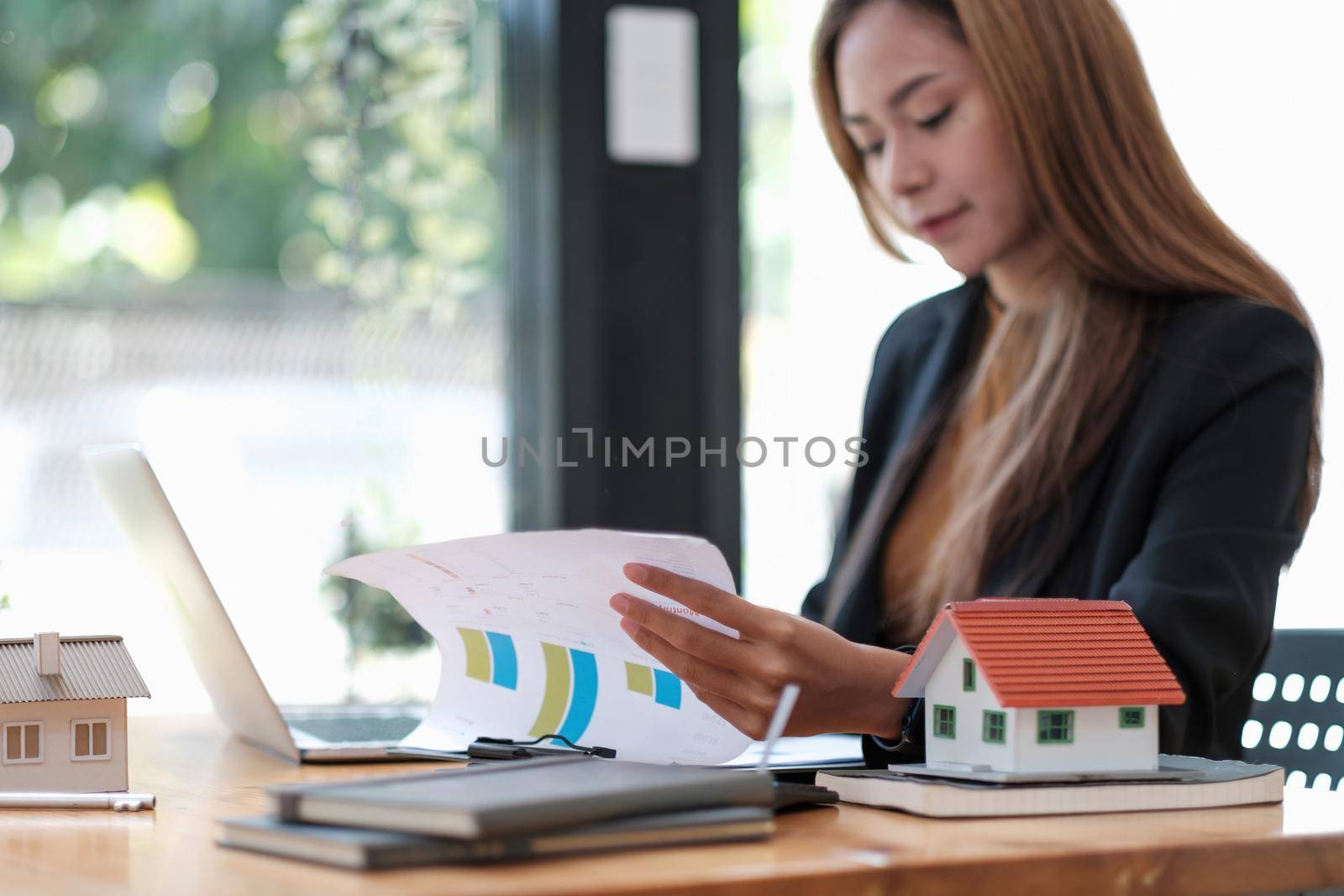 Business woman agent calculating loan of finance and investment for real estate, business woman and invest in property about home, construction or mortgage of home
