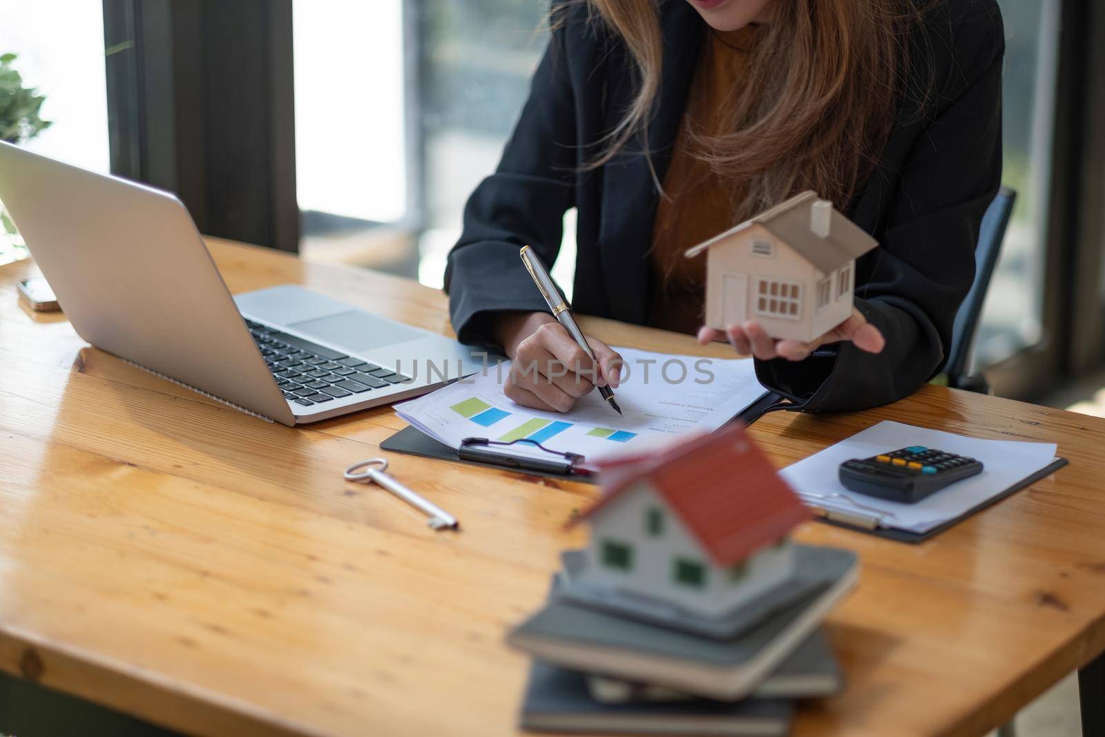 Business Financing Accounting Banking Concept, businesswoman doing finances and calculate about cost to real estate investment and tax.