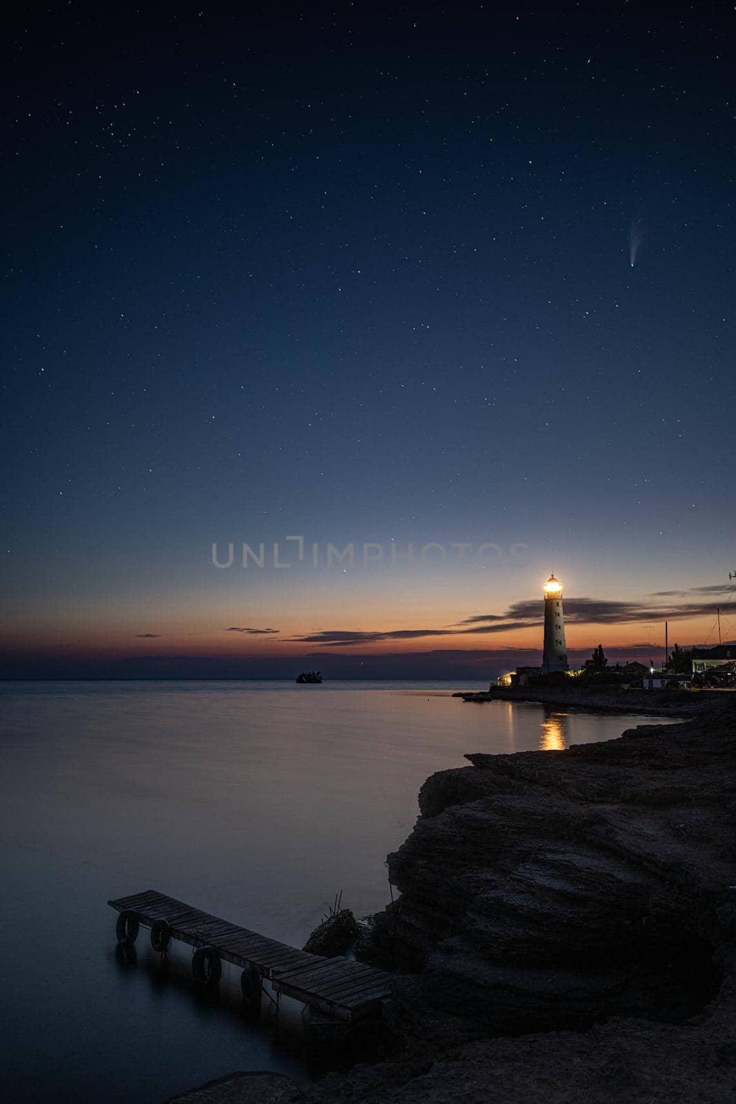 Vertical HDR Landscape view of Neowise comet over old lighthouse by MKolesnikov