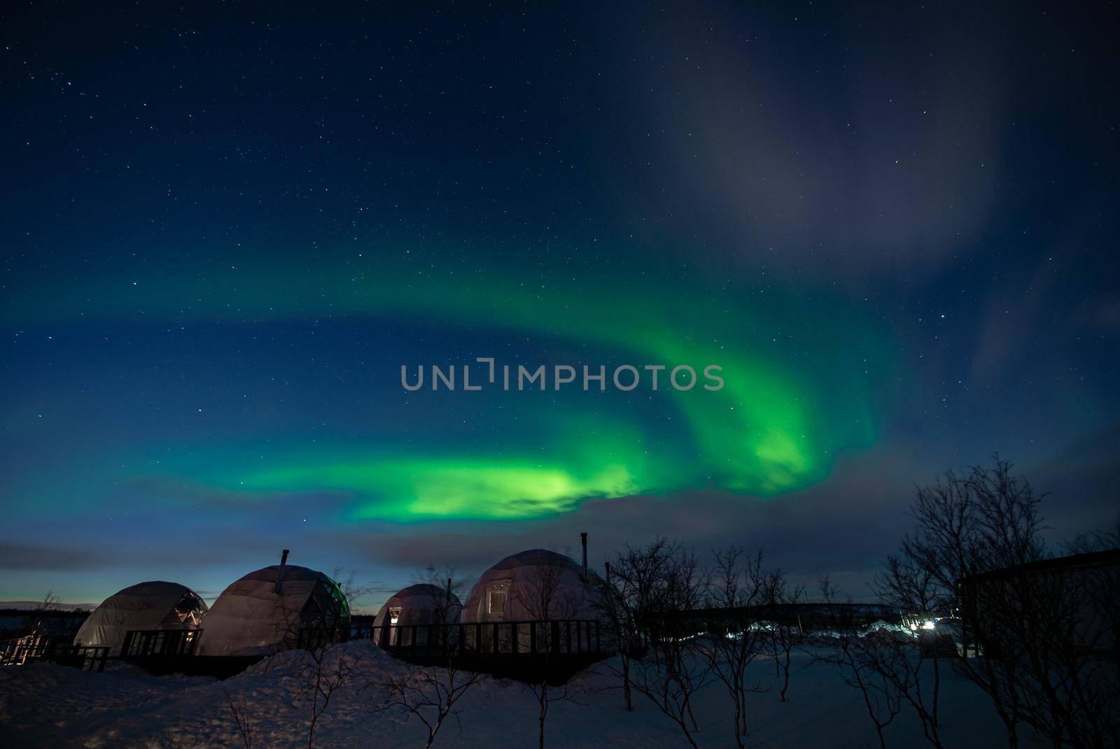 Northern Lights also known as aurora, borealis or polar lights at cold night over igloo village. Beautiful night photo of magic nature of winter landscape by MKolesnikov