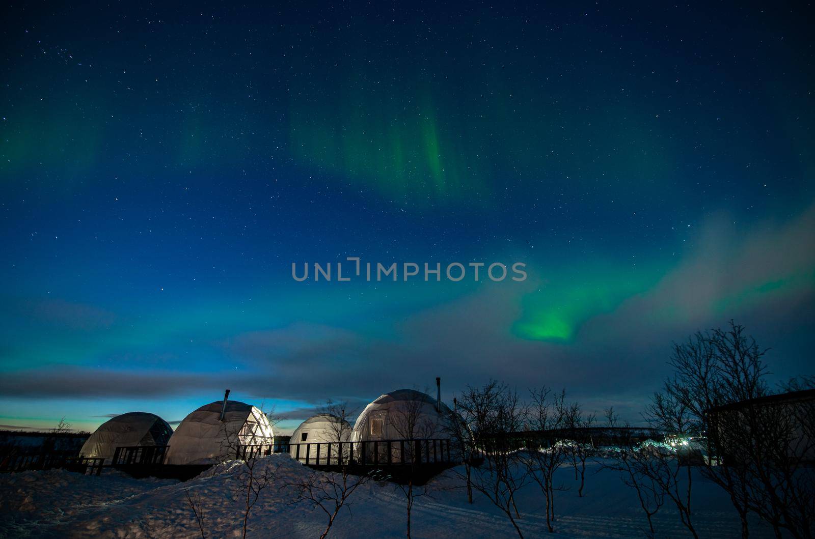 Northern Lights also known as aurora, borealis or polar lights at cold night over igloo village. Beautiful night photo of magic nature of winter landscape by MKolesnikov