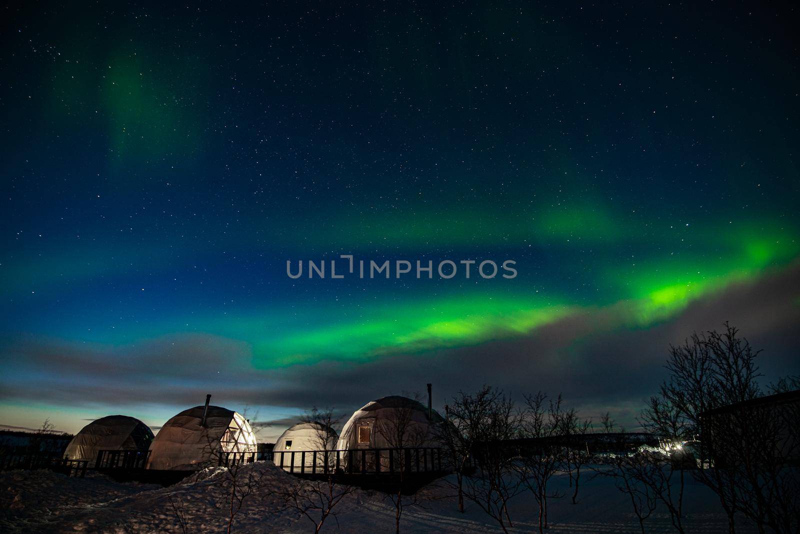 Northern Lights also known as aurora, borealis or polar lights at cold night over igloo village. Beautiful night photo of magic nature of winter landscape by MKolesnikov