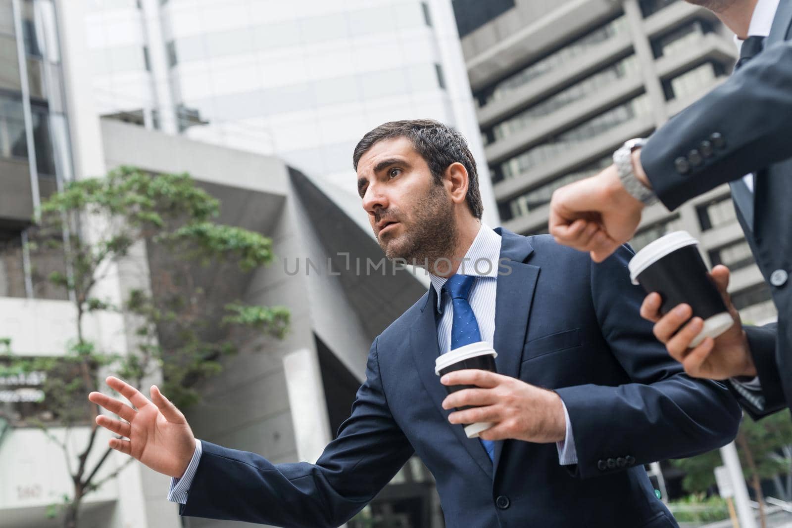 Two handsome businessmen stopping car with hand outdoors