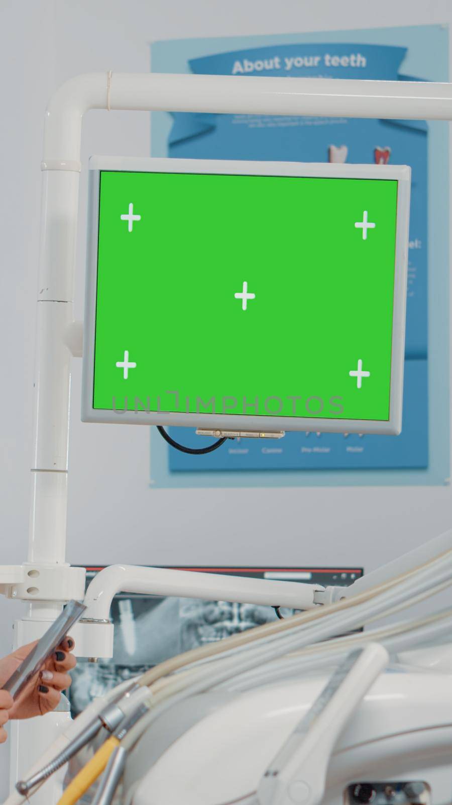 Dentist analyzing horizontal green screen on monitor and radiography of teeth for dental care. Woman using chroma key and mockup template for oral examination and teethcare in cabinet.