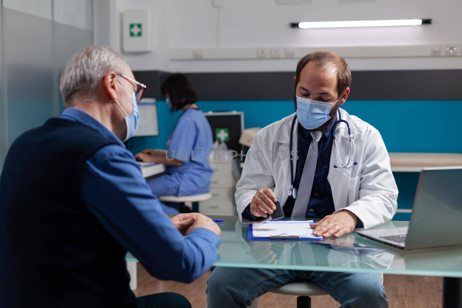 Practitioner putting medical seal on prescription paper by DCStudio