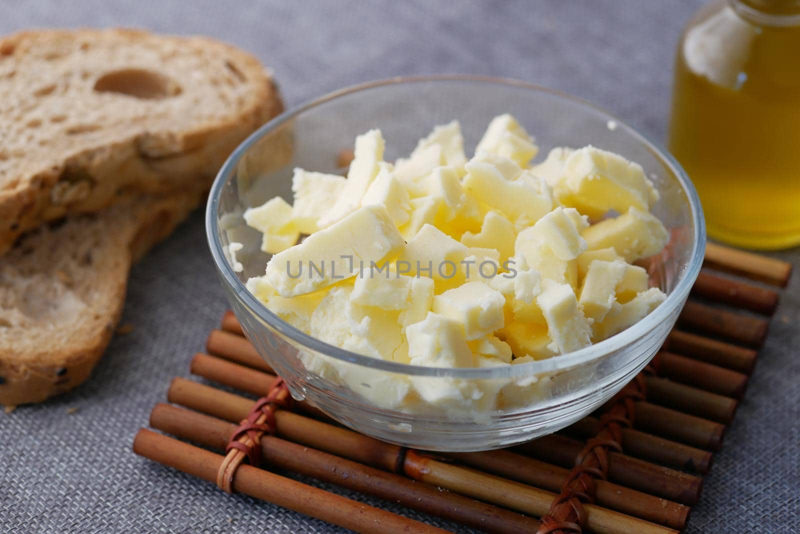 fresh butter in a container with bread on white background .