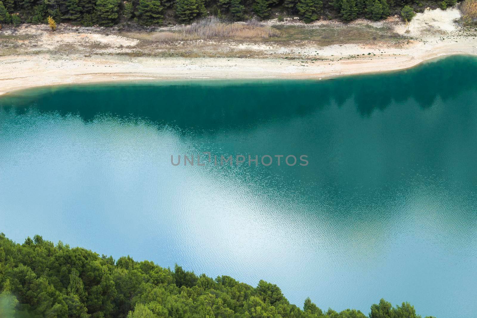 Reflections on the colorful swamp of Guadalest village surrounded by vegetation and mountains on a sunny day