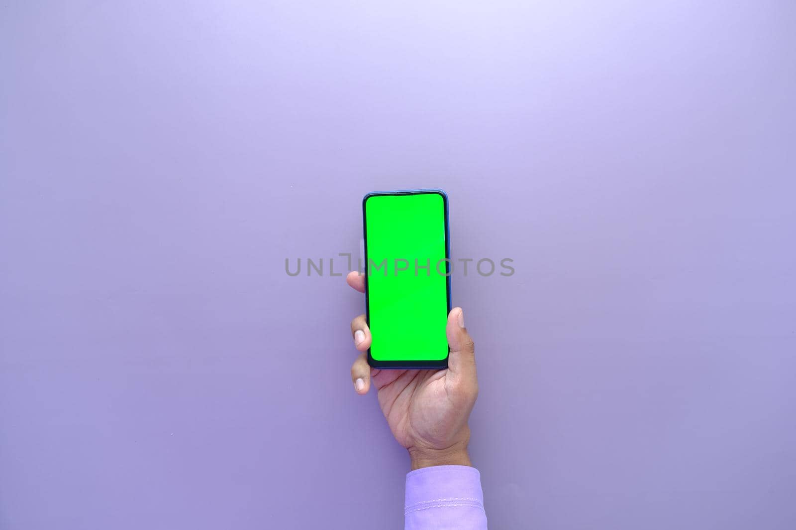 top view of young man hand using smart phone with green screen .