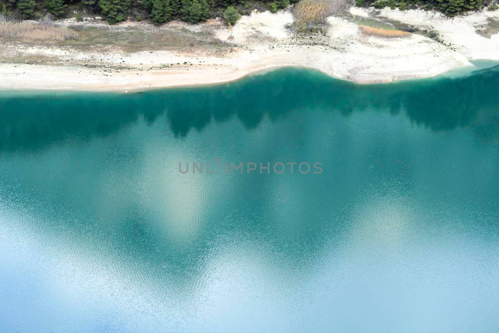 Reflections on the colorful swamp of Guadalest village surrounded by vegetation and mountains on a sunny day