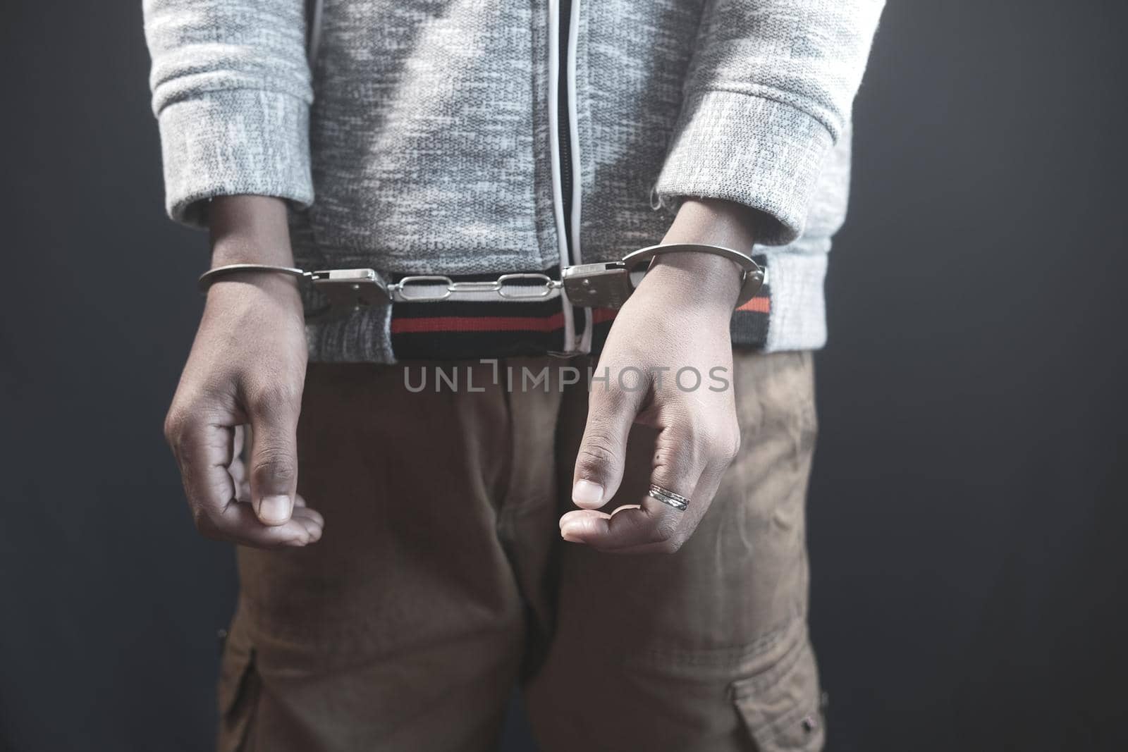 man's hand with handcuff on black background..