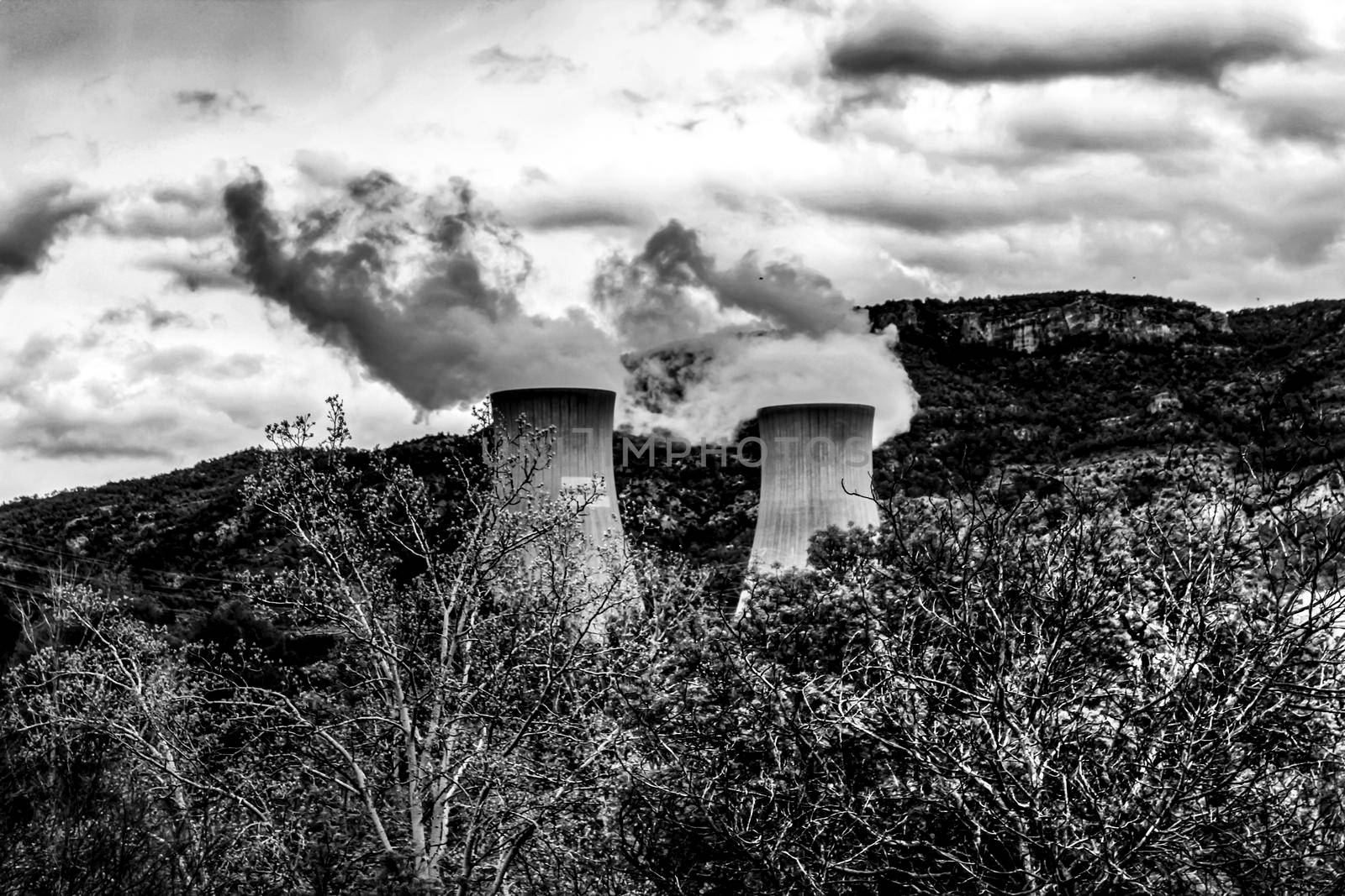 Smoking chimneys in Cofrentes nuclear power plant between mountains in Valencia, Spain