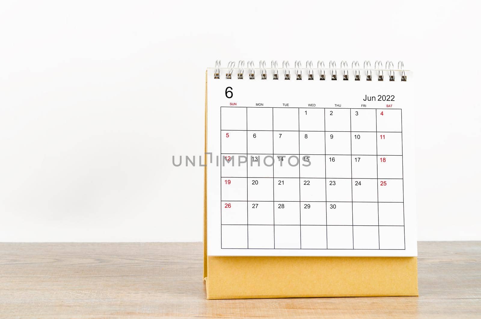 The June 2022 desk calendar on wooden table.