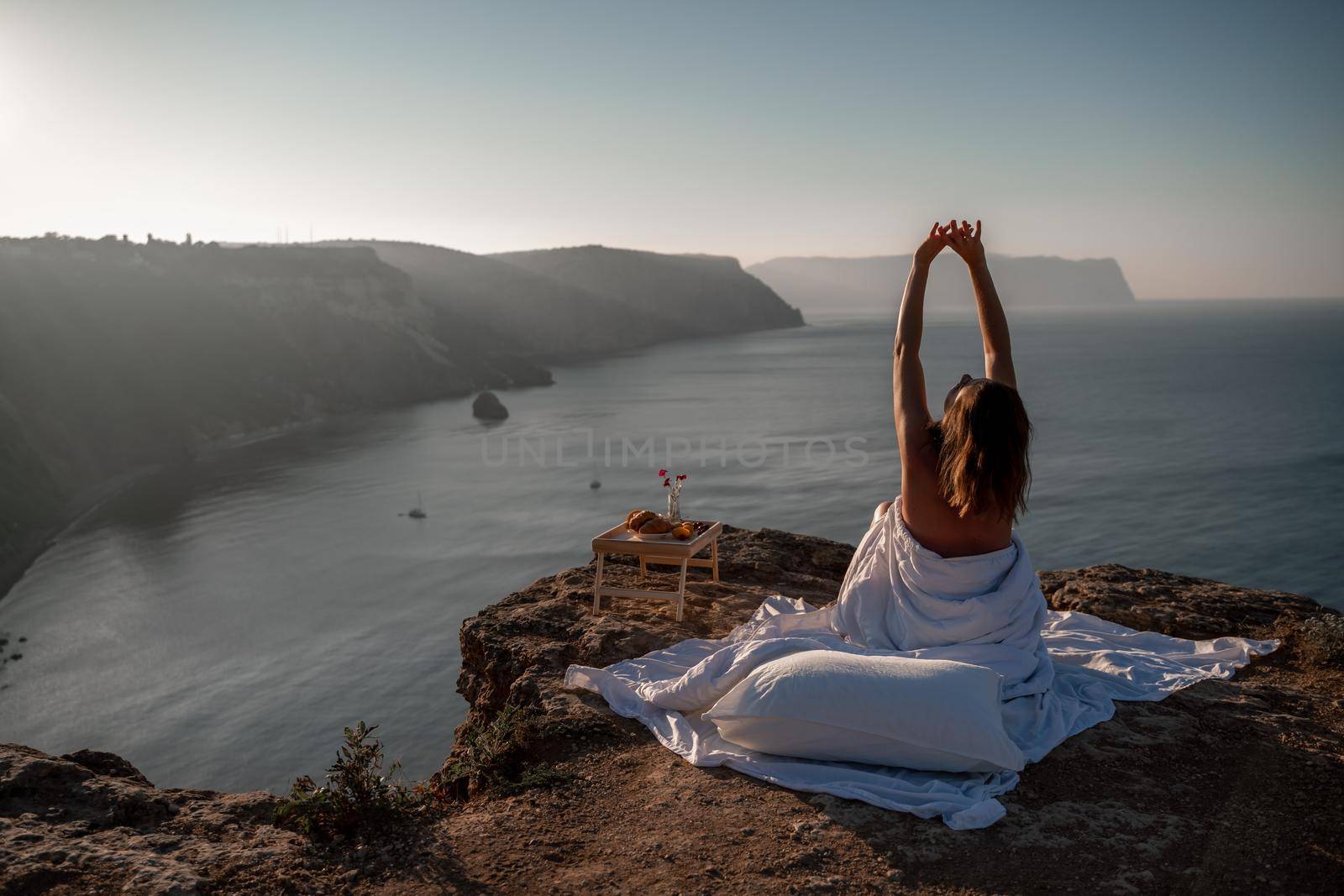 Woman wake up in bed wuth duvet and pillow over nature sea background outdoors. Back view. Good morning. Freedom concept. by Matiunina