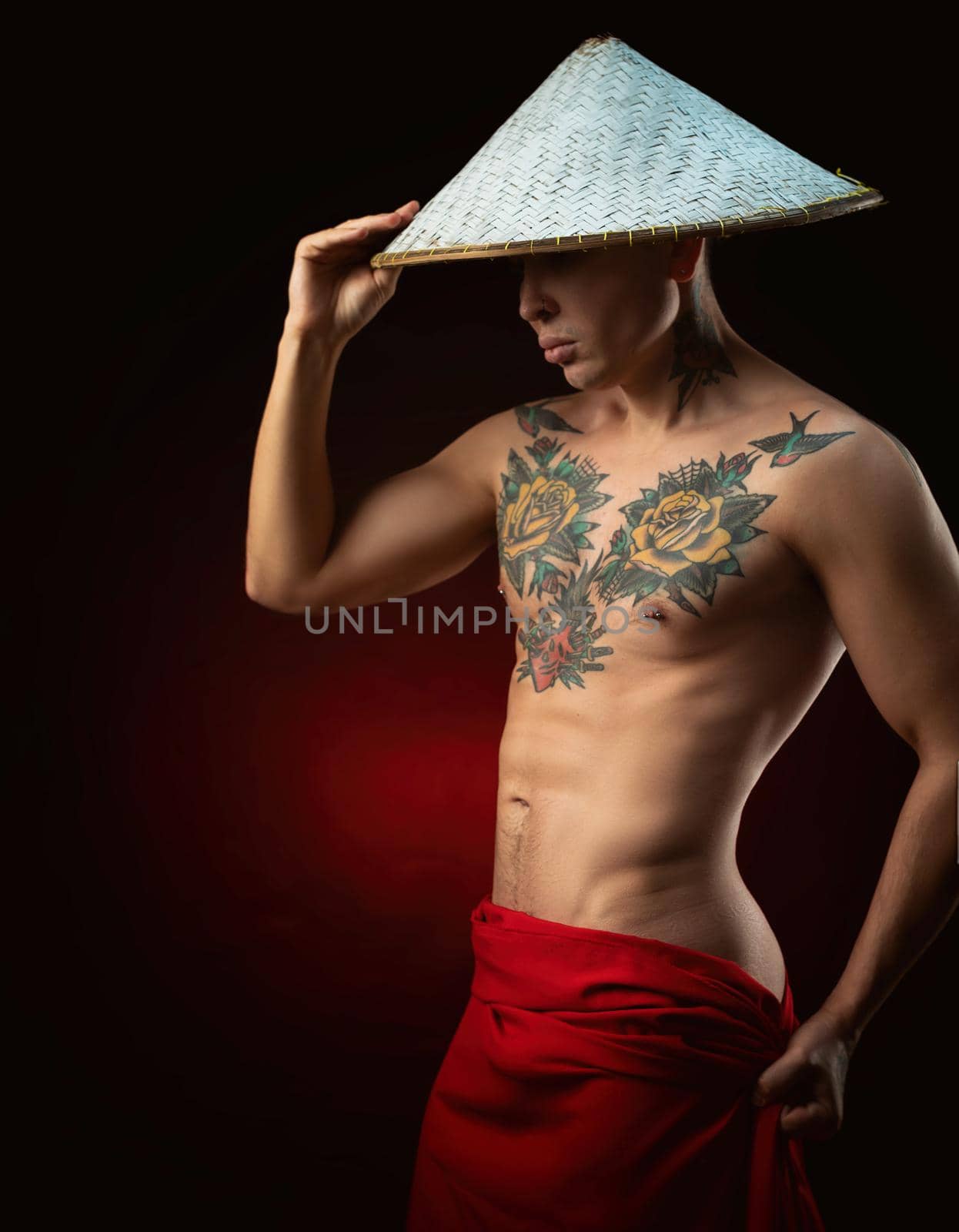 a half-naked male monk in a triangular Asian hat