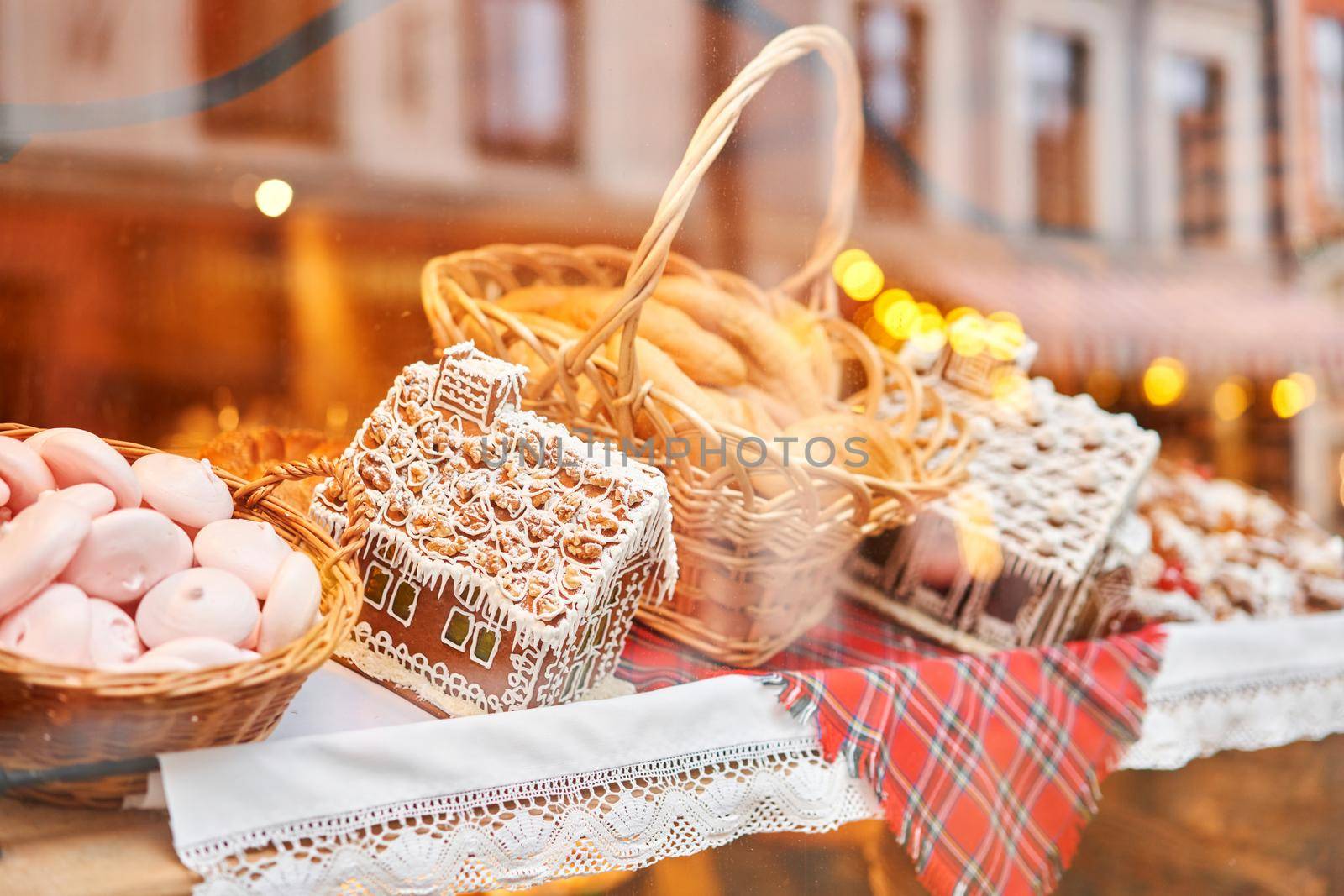 A bakery showcase in a European city for Christmas. Gingerbread house, pretzel, apple crumble, buns. Bread on Christmas and New year by Malkovkosta