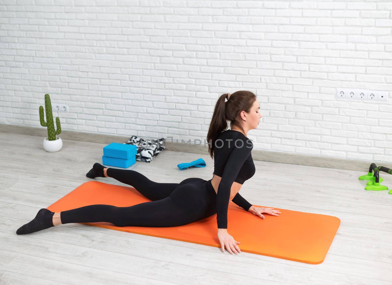 girl conducts a home workout stretching to strengthen her back