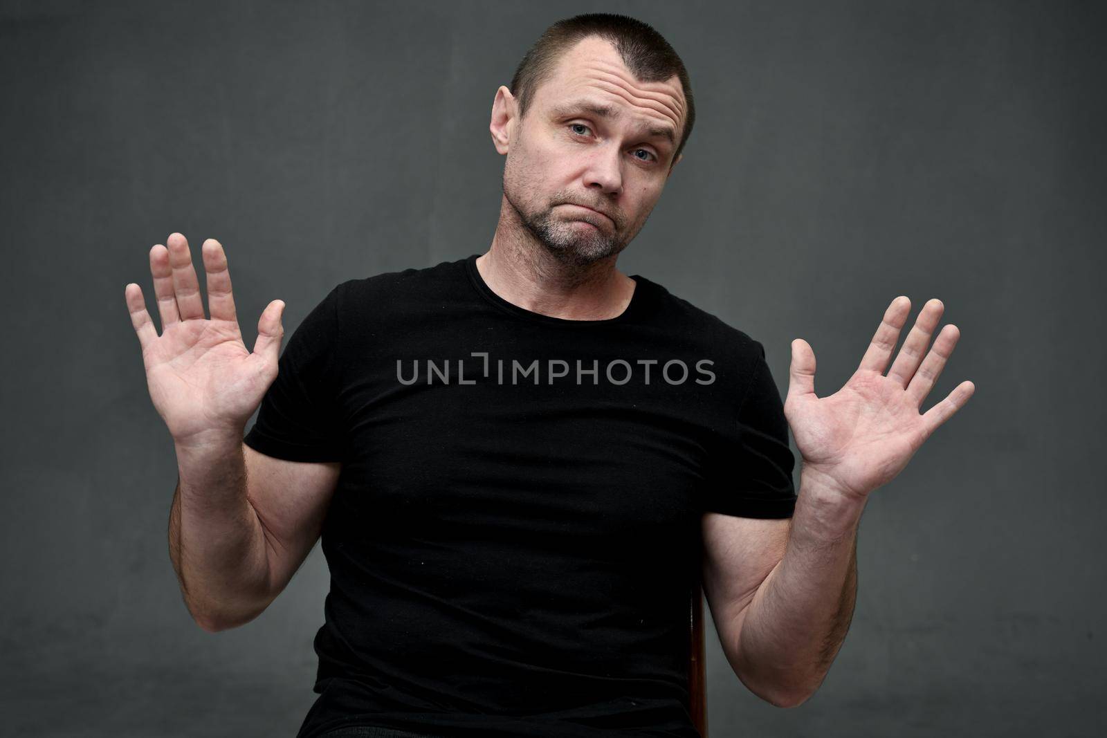 Portrait of an adult man with emotion hands shows no
